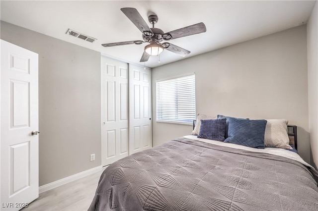 bedroom with light hardwood / wood-style floors, a closet, and ceiling fan