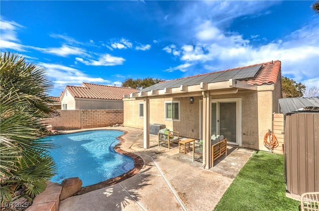 back of house featuring a fenced in pool, a patio area, and solar panels