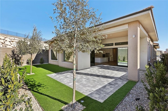 back of property featuring a patio and a yard