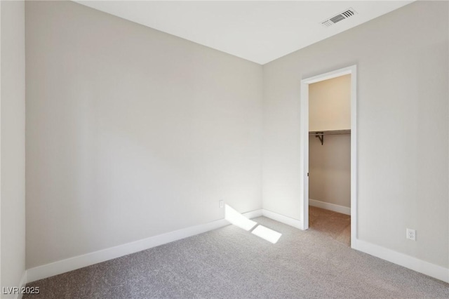 unfurnished bedroom featuring a spacious closet, carpet floors, and a closet