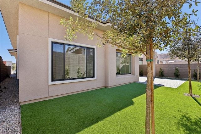 rear view of property featuring a patio area and a lawn