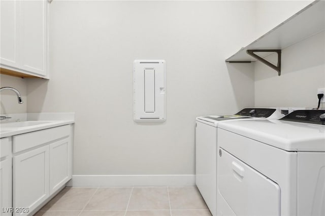 laundry room with cabinets, washer and clothes dryer, sink, and light tile patterned floors