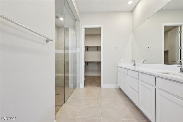 bathroom with vanity, a tile shower, and tile patterned floors