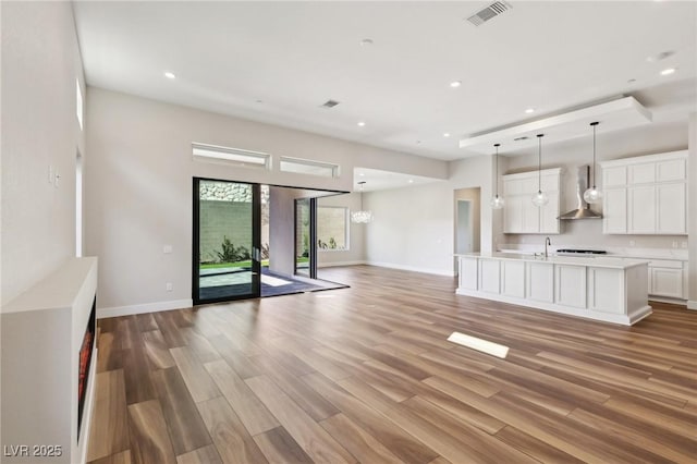 unfurnished living room with sink and light wood-type flooring