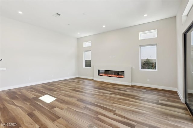 unfurnished living room with a wealth of natural light and light wood-type flooring