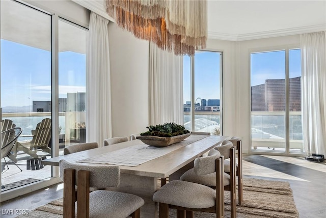 dining area with crown molding and a water view