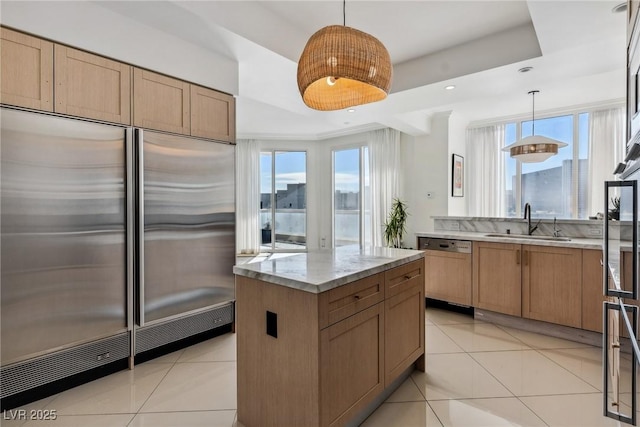 kitchen featuring light tile patterned floors, sink, dishwasher, hanging light fixtures, and stainless steel built in refrigerator