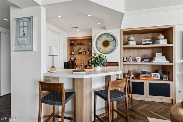 bar featuring crown molding, built in features, and dark parquet floors