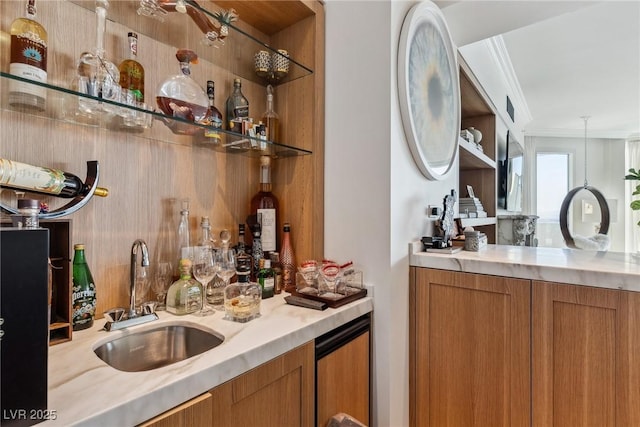 bar featuring crown molding, decorative light fixtures, and sink