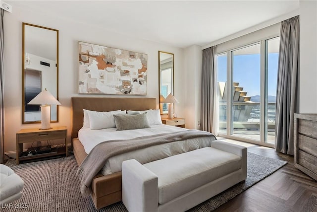 bedroom with dark parquet flooring and access to outside