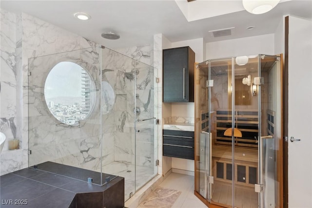 bathroom with an enclosed shower, tile patterned flooring, and tile walls