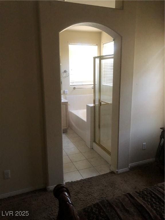 bathroom featuring vanity, plus walk in shower, and tile patterned flooring