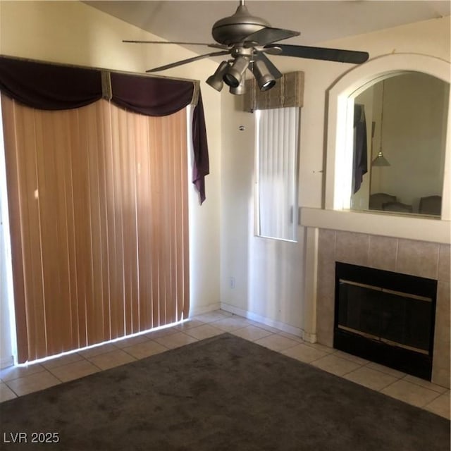 unfurnished living room with ceiling fan, light tile patterned floors, and a fireplace