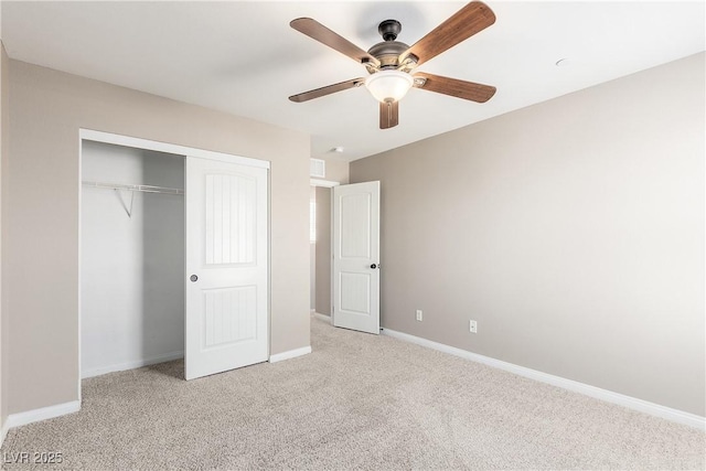 unfurnished bedroom featuring ceiling fan, light colored carpet, and a closet