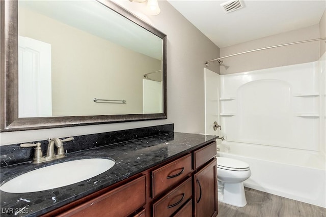 full bathroom featuring vanity, toilet,  shower combination, and wood-type flooring