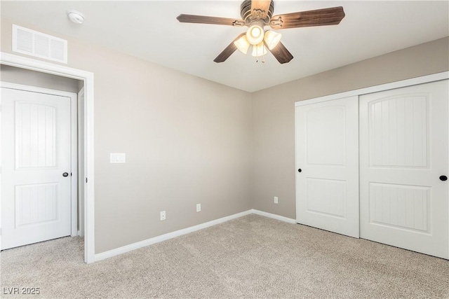 unfurnished bedroom featuring light carpet, a closet, and ceiling fan