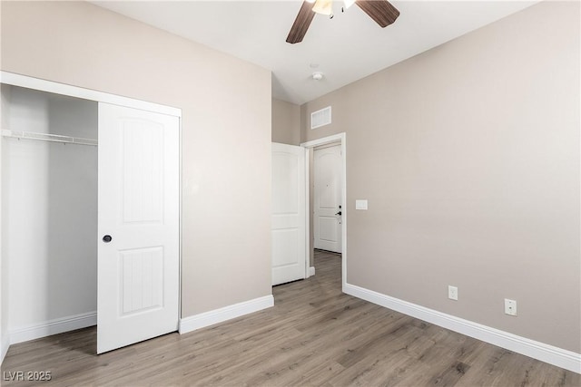 unfurnished bedroom featuring light hardwood / wood-style flooring, ceiling fan, and a closet