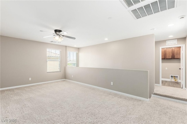 carpeted spare room featuring ceiling fan