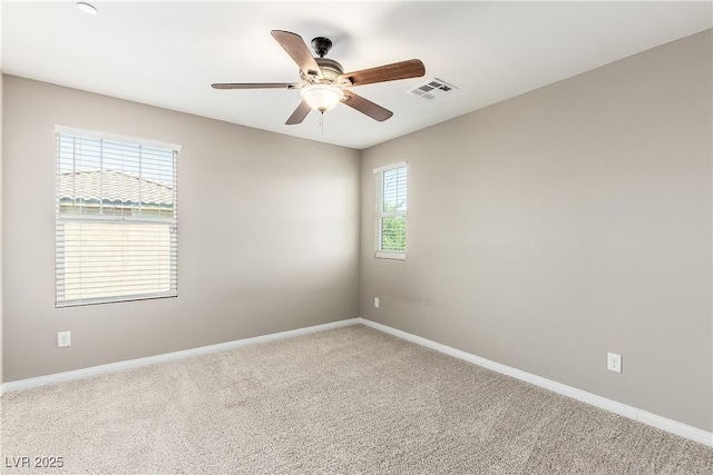 spare room with ceiling fan, a healthy amount of sunlight, and carpet