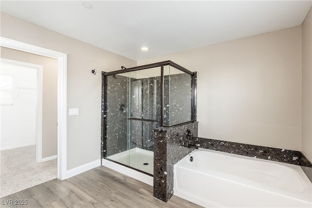 bathroom featuring wood-type flooring and independent shower and bath