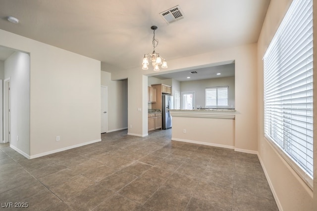 unfurnished living room featuring a chandelier