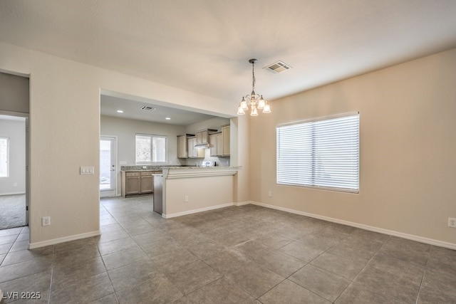 interior space featuring tile patterned floors, hanging light fixtures, kitchen peninsula, a notable chandelier, and wall chimney range hood