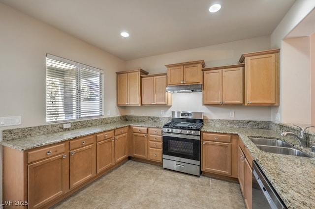 kitchen with sink, light stone countertops, and appliances with stainless steel finishes