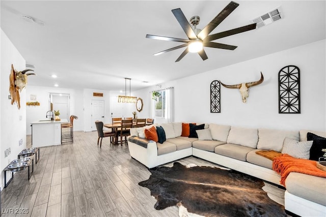 living room featuring ceiling fan and sink