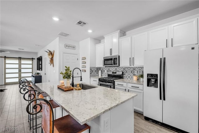 kitchen featuring white cabinetry, an island with sink, and appliances with stainless steel finishes