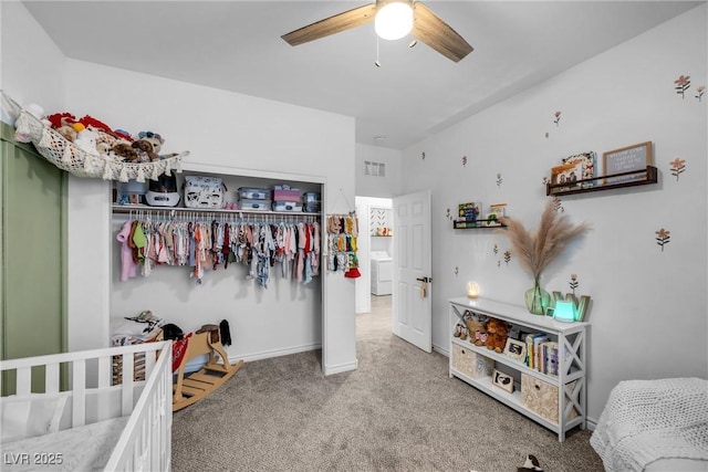 carpeted bedroom featuring washer / dryer, ceiling fan, and a closet