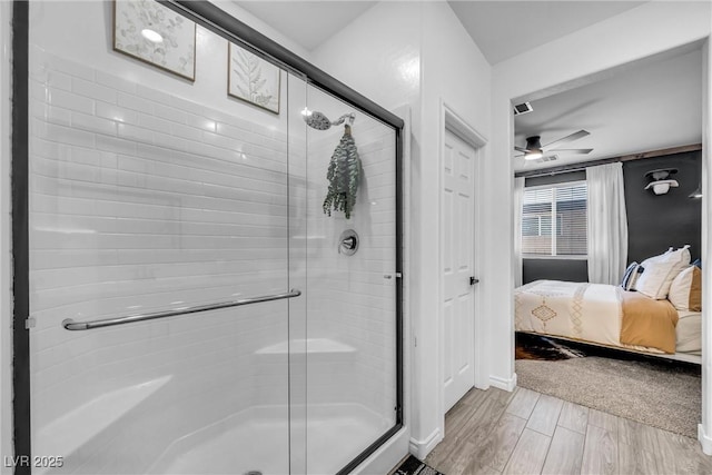 bathroom with a shower with door and ceiling fan