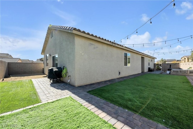 back of house with a yard and a patio area