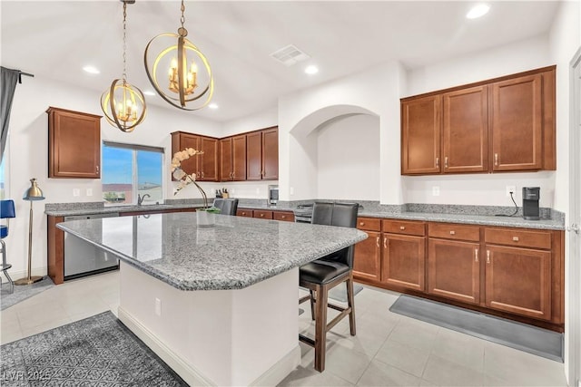 kitchen featuring sink, a breakfast bar area, dishwasher, a center island, and decorative light fixtures