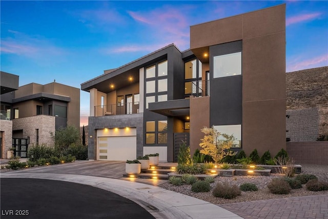 contemporary house with a garage and a balcony