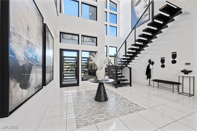 entrance foyer with a towering ceiling and tile patterned floors