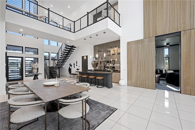 tiled dining space featuring a towering ceiling