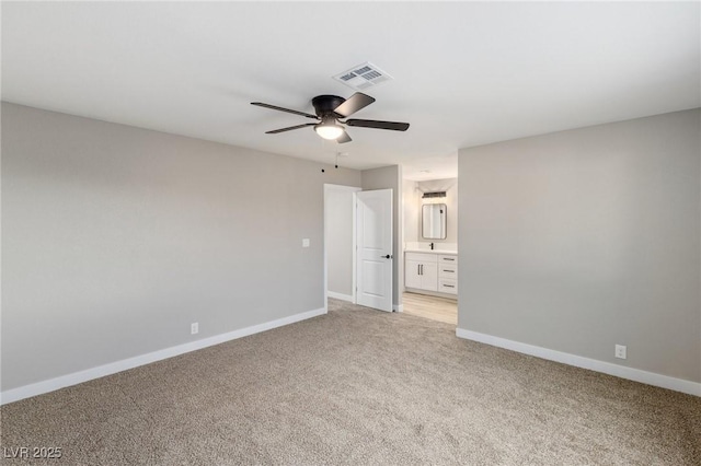 unfurnished bedroom featuring ceiling fan, ensuite bathroom, and light carpet