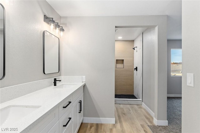 bathroom with hardwood / wood-style flooring, vanity, and a shower