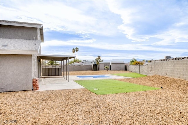 view of yard featuring a storage shed and a patio area