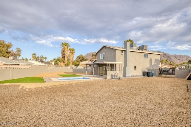 rear view of house with cooling unit, a patio, and a sunroom