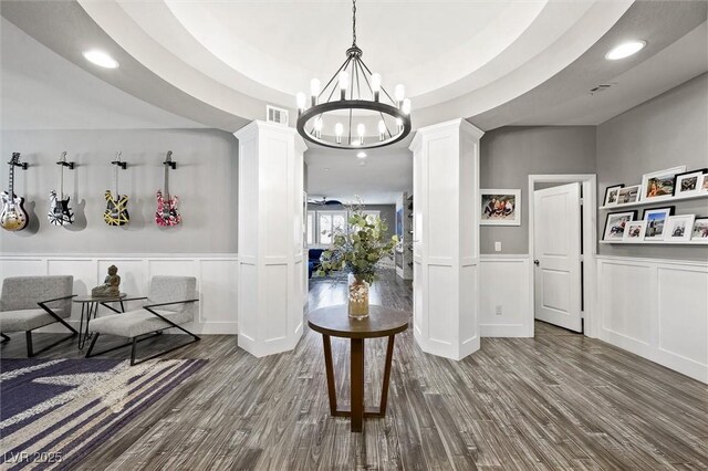 dining space featuring a chandelier, decorative columns, and hardwood / wood-style floors