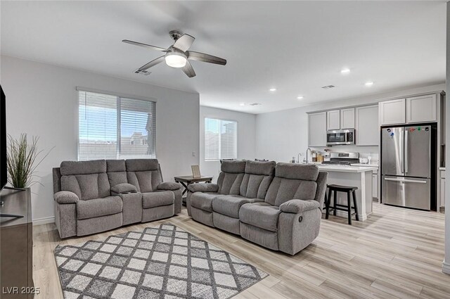 living room featuring ceiling fan and light hardwood / wood-style flooring