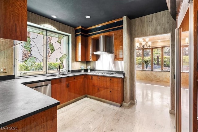 kitchen featuring wall chimney range hood, a wealth of natural light, stainless steel appliances, and sink