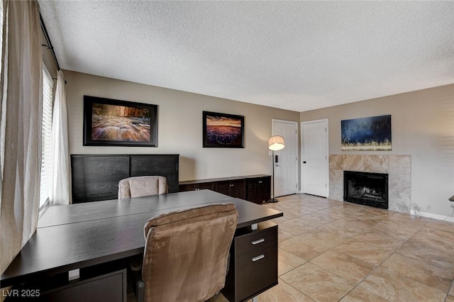 office space with a tile fireplace and a textured ceiling