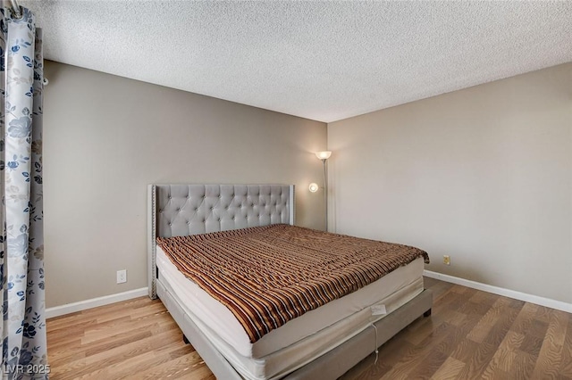 bedroom with hardwood / wood-style flooring and a textured ceiling