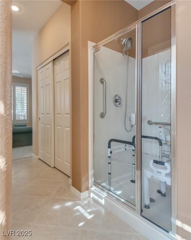 bathroom with an enclosed shower and tile patterned flooring