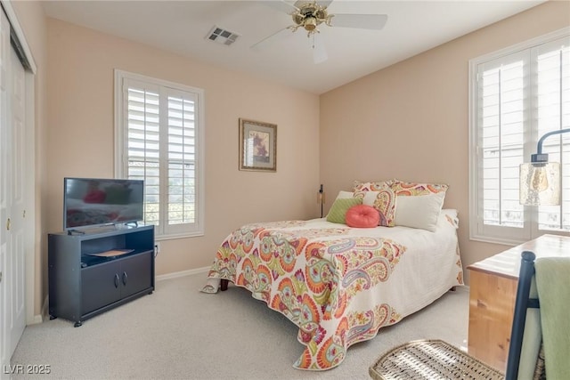 carpeted bedroom with ceiling fan and a closet