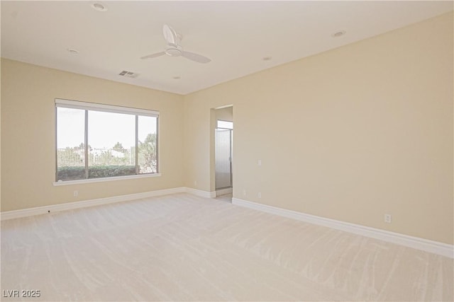 empty room featuring baseboards, light carpet, and visible vents