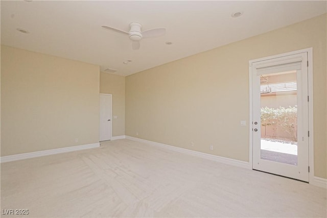 spare room with baseboards, ceiling fan, and light colored carpet