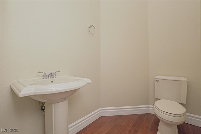 bathroom with hardwood / wood-style flooring and toilet